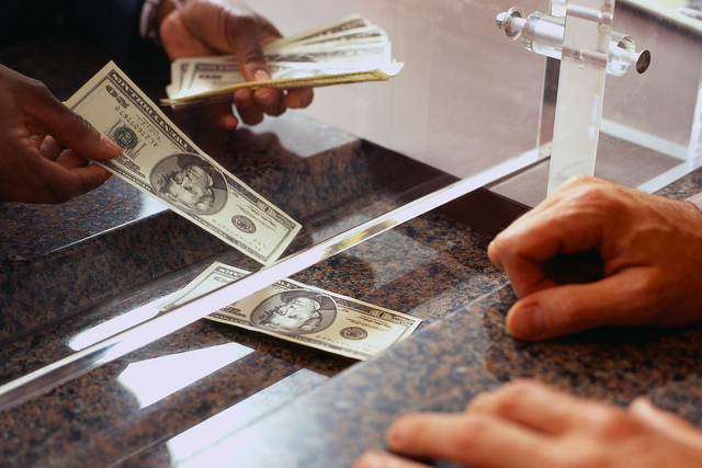 Bank Teller Counting Money for Customer